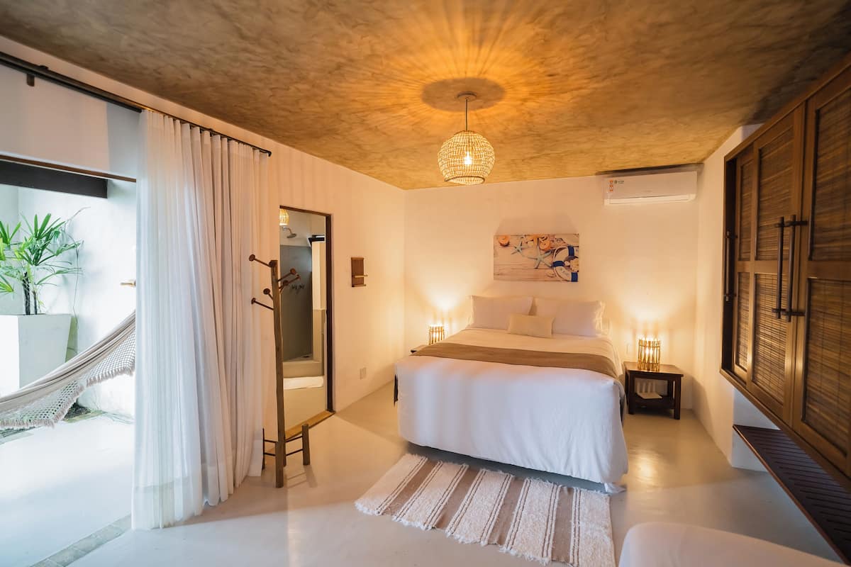 Suite casal deluxe, cama Queen, vista parcial para o oceano, jardim | 1 habitación, ropa de cama de alta calidad y minibar