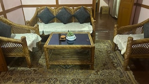 Una habitación con un conjunto de sofá, una mesa de centro y una alfombra estampada.