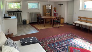 Un espace de vie compact comprenant une kitchenette, un coin repas et un espace détente.
