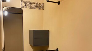 A bathroom with a mirror, a towel rack, a cabinet, and a sign that reads "DREAM". - Florence Cave House (Firenze)