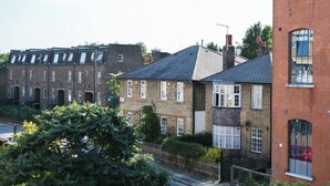 Une rangée de maisons mitoyennes aux façades en briques et aux toits à deux versants.