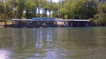 A riverside dock with a covered seating area and a sign for Anglers Trout Dock.