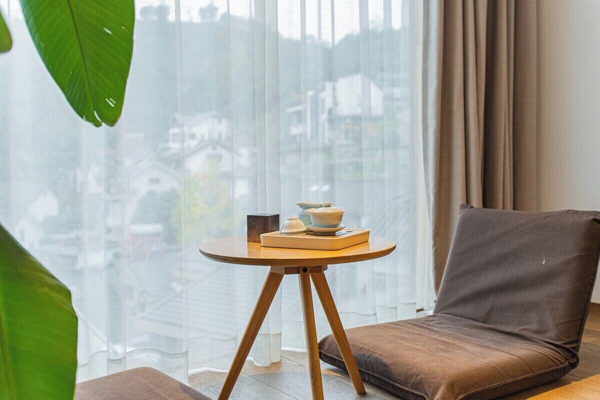 Un salon moderne avec un canapé et une table ronde en bois sur laquelle est posé un saladier.