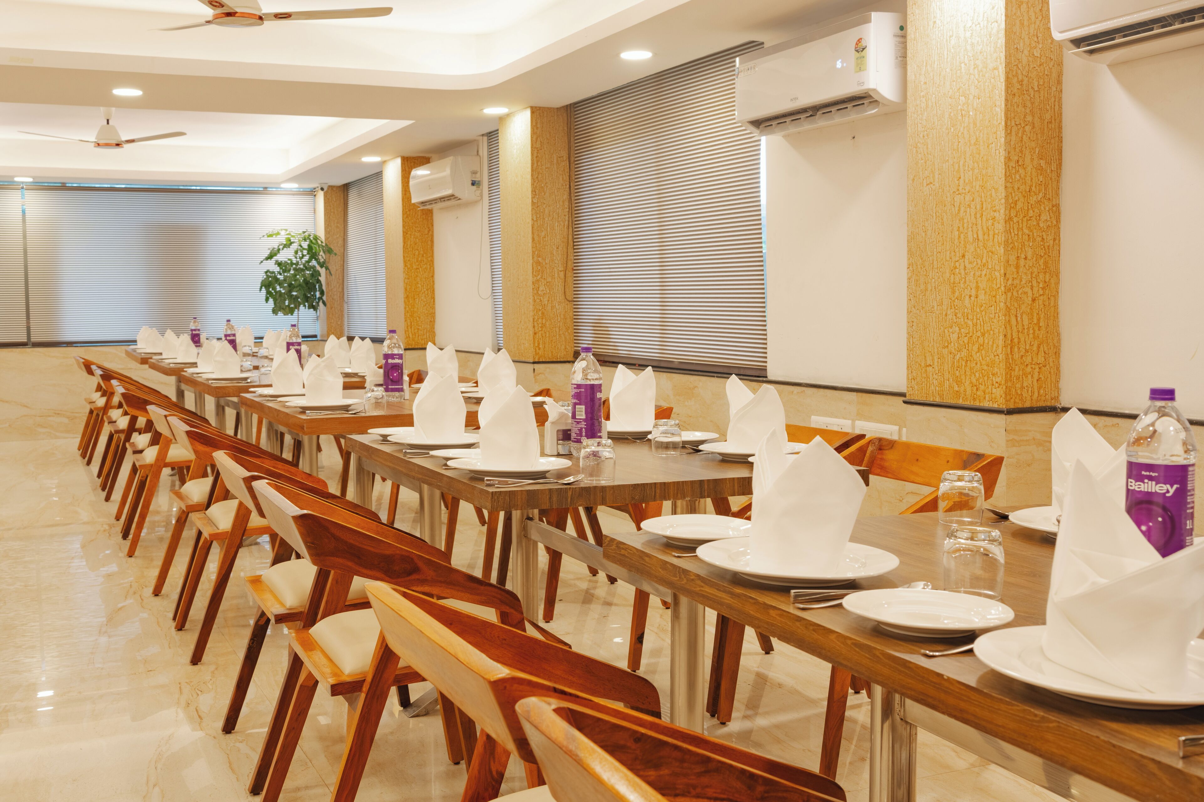 Une salle de conférence équipée de longues tables, de chaises et de climatiseurs.