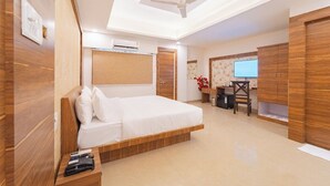 Ein modernes Schlafzimmer mit einem großen Bett, einem Holzschrank, einem Schreibtisch mit Stuhl und einem Deckenventilator.