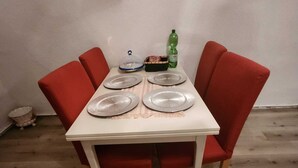 A dining table with four red chairs, a white tablecloth, and a bottle of soda. - "charmante 2 Zimmer Wohnung in Ansbach" (Ansbach)