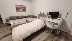 A small, modern room with a bed, a desk, a computer, and a couch. - "charmante 2 Zimmer Wohnung in Ansbach" (Ansbach)