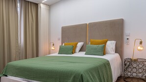 Une chambre d’hôtel avec un grand lit, deux tables de chevet et une fenêtre avec des rideaux.