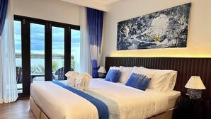 Een hotelkamer met een groot bed, uitzicht door het raam en een schilderij aan de muur.