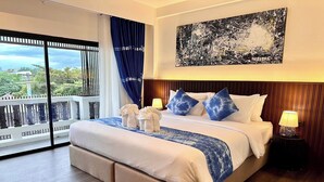 Een hotelkamer met een groot bed, een balkon met uitzicht en een schilderij aan de muur.