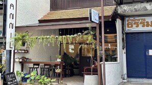 Een restaurant met terras, een bord en een blauwe luik.