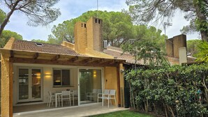 A covered patio with a seating area, a brick chimney, and a view of the surrounding trees. - Renovated Villa | Pool | Beach 300m Walk | 4 Guests | Pula Sardinia (Santa Margherita di Pula)