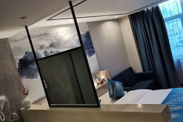 A modern hotel room with a bed, a desk, a chair, and a large window with curtains. - Qinyu Hotel (Haikou)