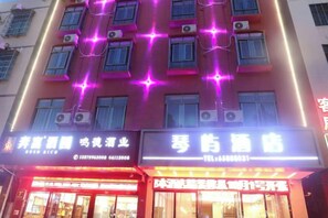 Een gebouw met verschillende winkels en uitgaansgelegenheden, waaronder een restaurant en een karaoke bar.