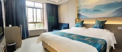 Una habitación de hotel con una cama grande, un escritorio, una silla y un televisor.