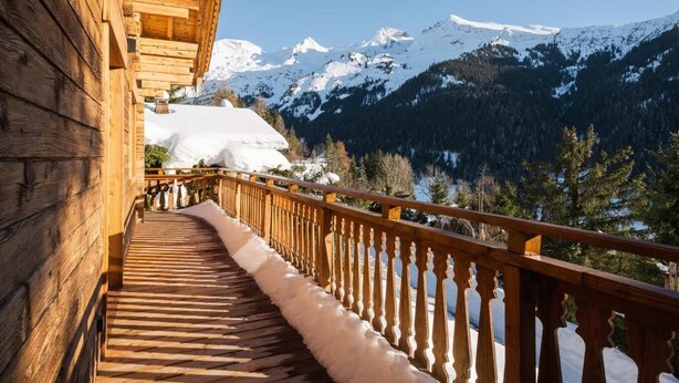 A wooden staircase leading to a balcony with a view of snow-covered mountains. - Chalet, view panoramic, terrace, fireplace or stove, parking, tv, ski locker, 168m², La Clusaz (La Clusaz)