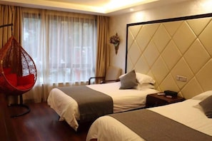 Une chambre d’hôtel avec deux lits, un fauteuil suspendu, une table de chevet et une grande fenêtre avec des rideaux.
