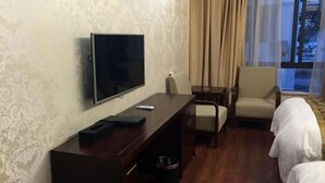 A hotel room with a TV, a desk, a chair, a small table, and a bed. - Yandang Mountain Yijingge Homestay (Yueqing)