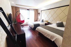 Une chambre d’hôtel avec deux lits, un fauteuil suspendu, un bureau et une télévision.