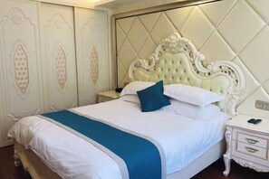 Un lit doté d’une tête de lit capitonnée, une table de chevet avec des tiroirs et un mur orné de moulures décoratives.