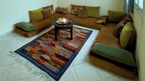 A living room with a sofa set, a coffee table, and a patterned rug. - Appartement à 10min des Plages et Souks. Amis à 4 Pates Acceptés ! (Agadir)