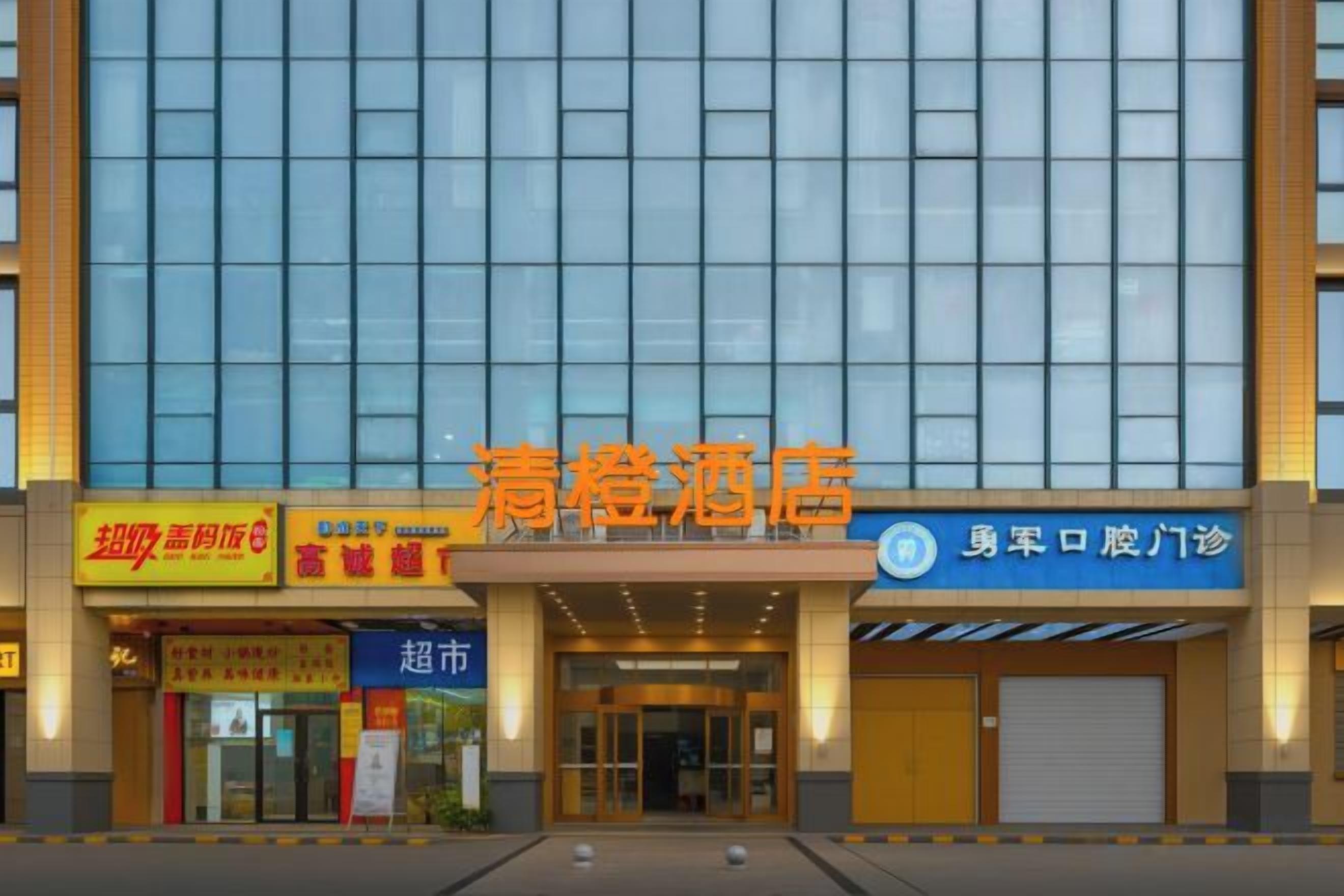 Un hotel con fachada moderna, varias tiendas y una entrada destacada.