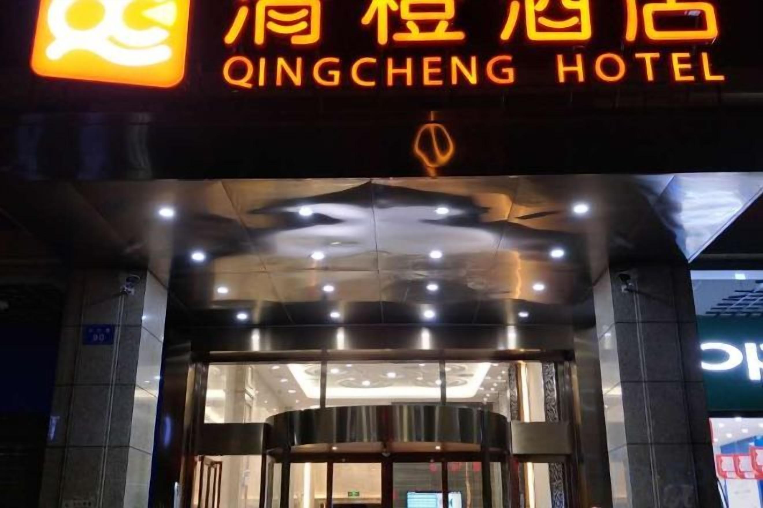 Ingången till Qingcheng Hotel, med en tydlig skylt ovanför dörren.
