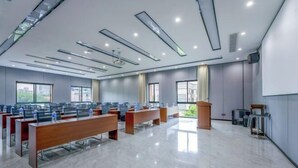 A modern conference room with rows of desks, a podium, and large windows. - Changsha Qingcheng Hotel (Mawangdui Huojucun Subway Station) (Changsha)