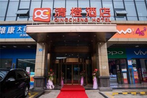 The entrance to Qingcheng Hotel with a red carpet, a signboard, and a car parked in front. - Changsha Qingcheng Hotel (Mawangdui Huojucun Subway Station) (Changsha)