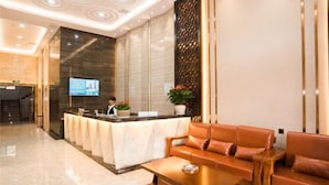 A modern hotel lobby with a reception desk, leather seating, and a decorative wall. - Changsha Qingcheng Hotel (Mawangdui Huojucun Subway Station) (Changsha)
