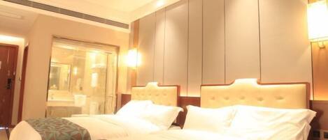 A hotel room with two beds, a large mirror, and a bedside telephone.