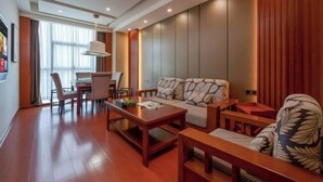 A modern hotel room with a wooden floor, a sofa, a dining table, and a desk. - Changsha Qingcheng Hotel (Mawangdui Huojucun Subway Station) (Changsha)