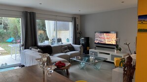 A modern living room with a sofa, coffee table, and TV. - Le Mas de Fabregas. Chambre Dhôte Calme et Tranquille à 400m de la mer (La Seyne-sur-Mer)