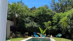 A backyard with a swimming pool, lounge chairs, and potted plants. - Le Mas de Fabregas. Chambre Dhôte Calme et Tranquille à 400m de la mer (La Seyne-sur-Mer)
