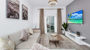 Un salon moderne avec un canapé, une table basse et un téléviseur fixé au mur.