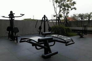 Outdoor exercise equipment, including a bench and a leg press machine, in a park setting. - Brits Hotel Puri Indah (West Jakarta)