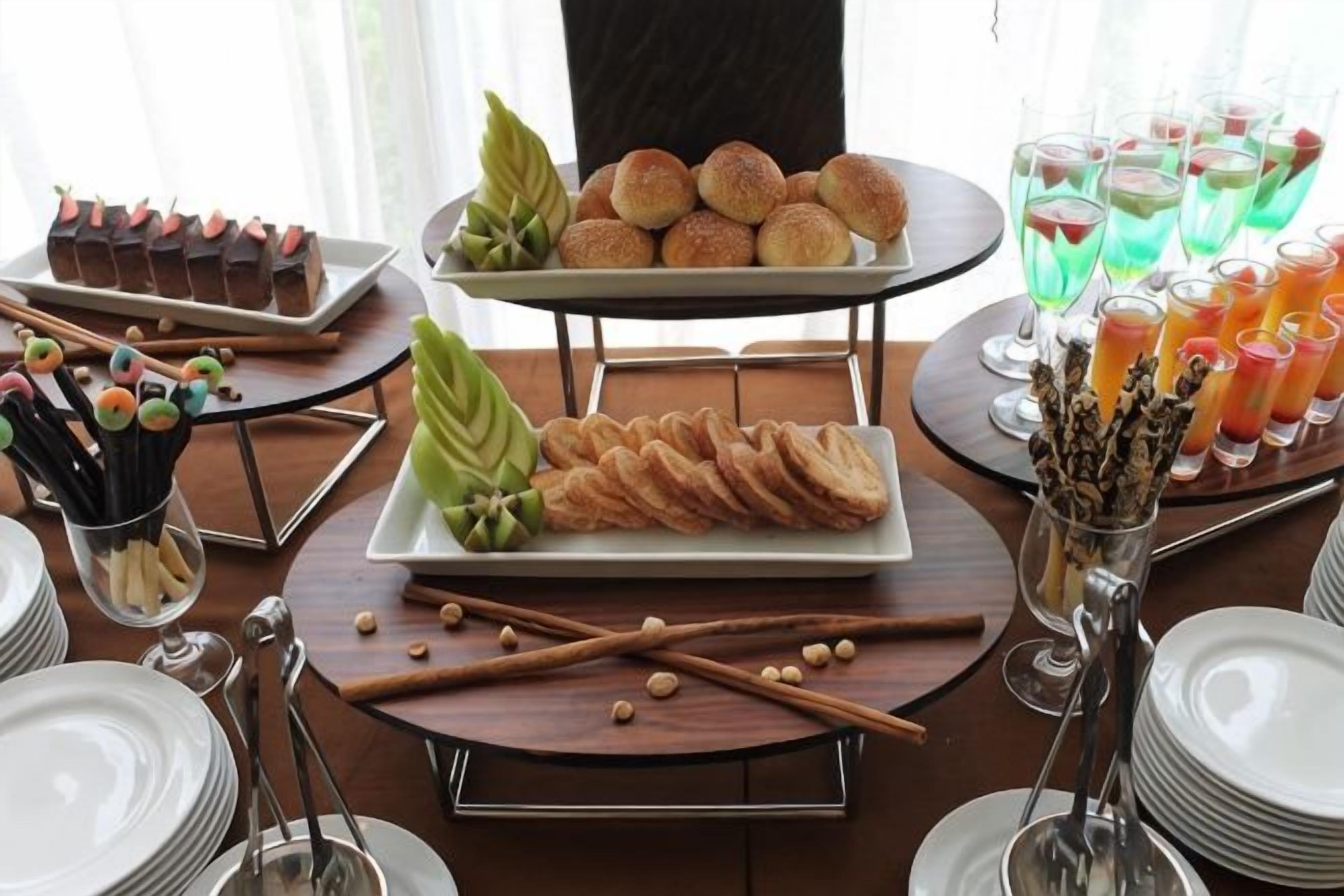 Una mesa de buffet con diferentes alimentos y bebidas.