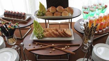 Una mesa de buffet con diferentes alimentos y bebidas.
