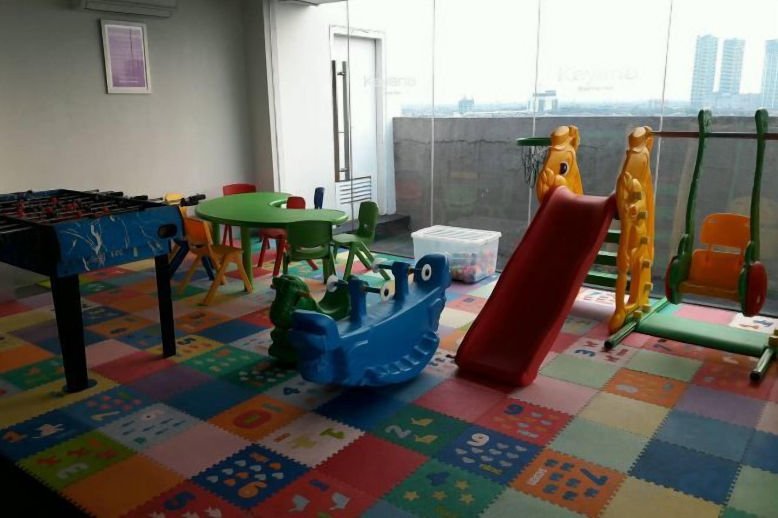A children's play area with a foosball table, a slide, and a playhouse.