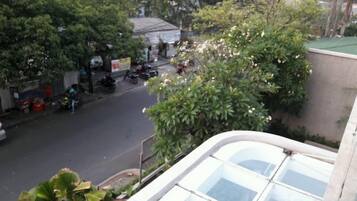A street view with a building in the foreground and trees in the background.