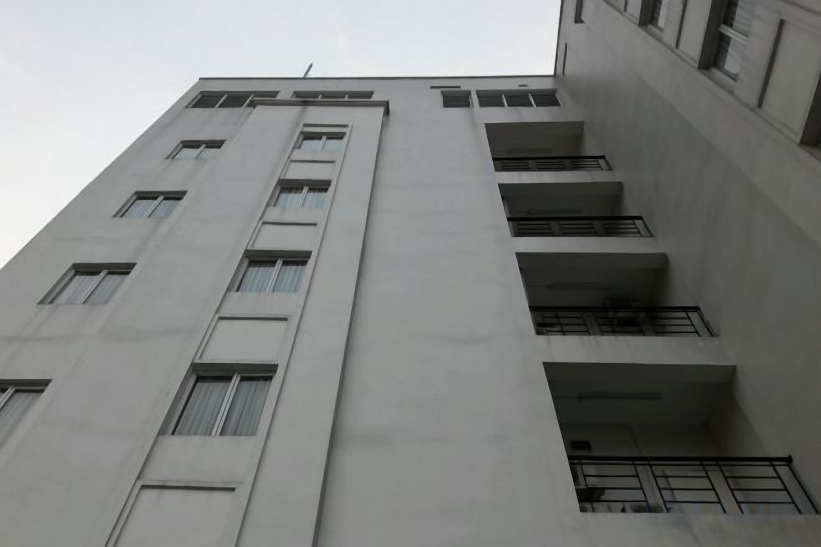 Un edificio de varios pisos con una serie de balcones y ventanas.