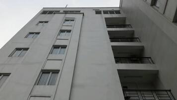 Un edificio de varios pisos con una serie de balcones y ventanas.