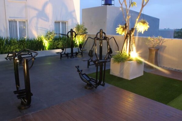 Outdoor exercise equipment, artificial grass, and potted plants. - Brits Hotel Puri Indah (West Jakarta)