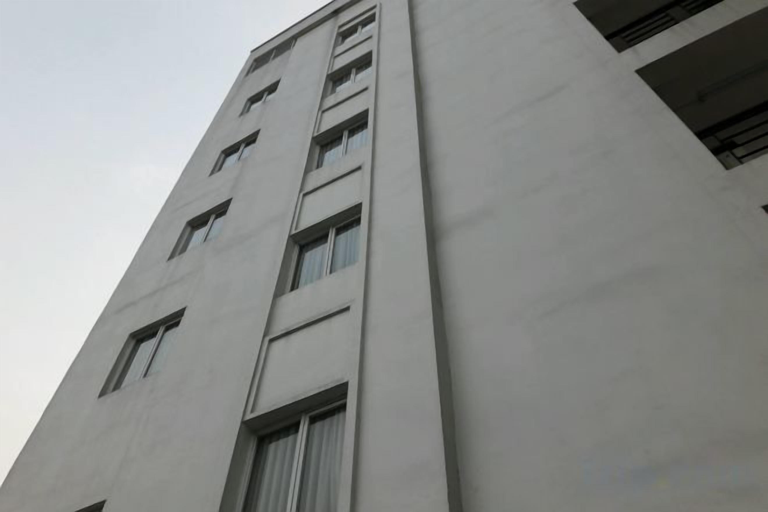 A tall building with multiple windows and a flat facade.