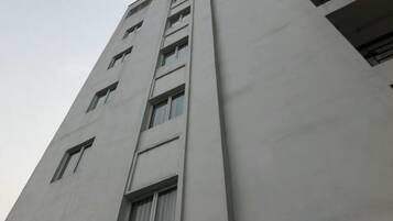A tall building with multiple windows and a flat facade.