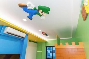 Habitación con un mural en el techo de un personaje, una ventana y un diseño de pared de ladrillos.