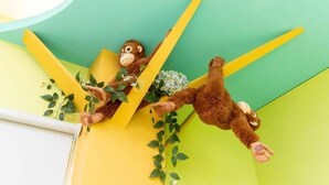 Two plush monkey figures on a yellow and green wall. - Field Time Homestay (Yilan)