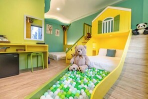 A room with a bed, a desk, a chair, a teddy bear, a ball pit, and a staircase. - Field Time Homestay (Yilan)
