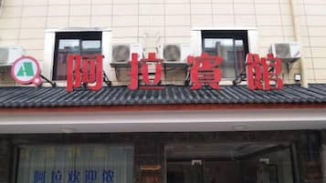 A building with a tiled roof and a sign with Chinese characters.