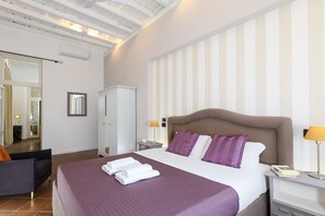 A hotel room with a large bed, a nightstand, a chair, and a wardrobe. - Bernini al Borgo - St Peter Vatican (Rome)